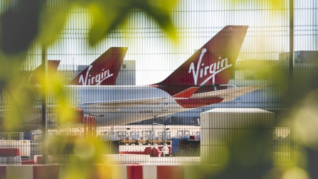A security fence stands near grounded passenger aircraft, operated by Virgin Atlantic Airways Ltd., at Manchester Airport, operated by Manchester Airport Plc, in Manchester, U.K., on Monday, June 1, 2020. More than 200 U.K. travel and hospitality executives, including the head of London’s iconic Ritz hotel, joined a chorus of airlines and airports calling for the government to introduce air bridges to boost tourism and scrap contentious plans to quarantine visitors. Photographer: Anthony Devlin/Bloomberg