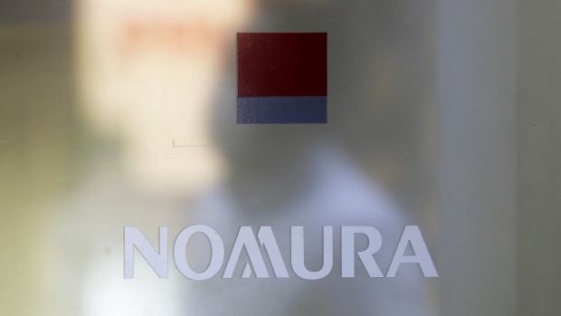Signage for Nomura Securities Co., a unit of Nomura Holdings Inc., is displayed on a glass door at one of the company's branches in Tokyo, Japan, on Monday, July 27, 2020. Nomura Holdings is schedule to announce first-quarter earning figures on July 29. Photographer: Kiyoshi Ota/Bloomberg