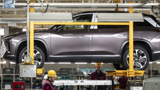 Workers install batteries onto an electric sport utility vehicle (SUV) during a media tour of the Nio Inc. production facility in Hefei, Anhui province, China, on Friday, Dec. 4, 2020. Nio is cementing its role as a challenger to Tesla Inc. in China's premium electric-vehicle segment, with both companies benefiting as the coronavirus pandemic recedes in the country.
