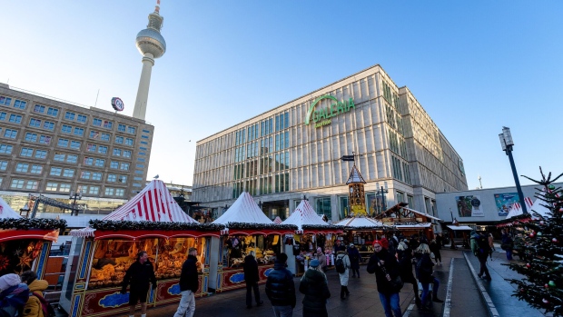 A Christmas market outside a Galeria Kaufhof department store, owned by Signa Holding GmbH, in Berlin, Germany, on Tuesday, Nov. 28, 2023. Austrian property tycoon Rene Benko transferred an 11.5% stake in Signa Holding GmbH to Swiss businessman Arthur Eugster in a sign of maneuvering around the embattled property and retail group as it holds last-ditch talks to secure emergency funding. Photographer: Krisztian Bocsi/Bloomberg