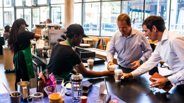 A barista serves customers their beverages at the pick-up counter inside a Starbucks Corp. cafe in the Sandton area of Johannesburg, South Africa, on Monday, Jan. 14, 2019. While South Africa's economy emerged from a recession in the third quarter, growth remains sluggish, hampered by subdued business confidence, higher taxes imposed by the government in February and a tight monetary-policy stance.