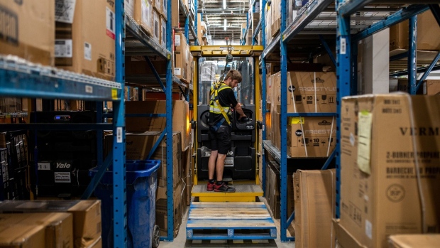A worker picks products with a lift in the warehouse of a Hillside Canadian Tire store in Victoria, British Columbia.