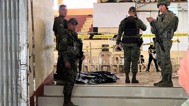 Military personnel stand guard at the entrance of a gymnasium while police investigators look for evidence after a bomb attack at Mindanao State University in Marawi, Lanao del sur province on Dec. 3. Photographer: Merlyn Manos/AFP/Getty Images