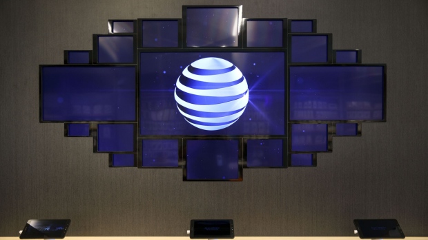 Signage is displayed on a video screen at an AT&T Inc. store in Newport Beach, California, U.S., on Thursday, Aug. 10, 2017. AT&T Inc. shares surged the most in more than eight years after the telecommunications giant posted a surprise wireless subscriber gain in the second quarter, showing it can fend for itself in a cutthroat price war. An offer for unlimited wireless data, bundled with discounted streaming-TV service, helping AT&T bide its time while awaiting regulatory approval to transform into a media powerhouse through the $85.4 billion purchase of Time Warner Inc. Photographer: Patrick T. Fallon/Bloomberg