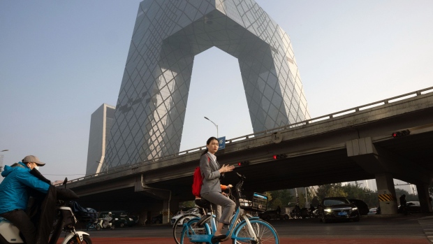 A morning commuter on a bicycle near the CCTV tower in Beijing, China, on Monday, Oct. 30, 2023. China's stock turnover rose above 1 trillion yuan ($136 billion) Oct. 30 for the first time in about two months, in a sign that trading appetite is returning after policymakers took more steps to boost demand. Bloomberg