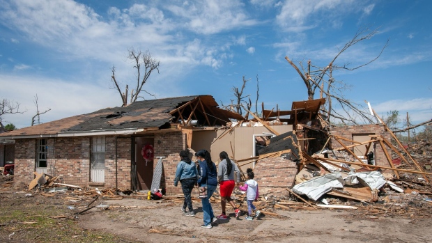 A family visits their destroyed home following a tornado in Rolling Fork, Mississippi, US, on Wednesday, March 29, 2023. President Joe Biden issued an emergency declaration for Mississippi, making federal funding available to hardest hit areas.
