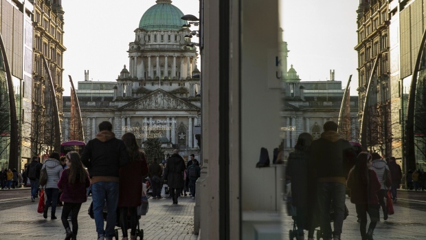 Shoppers walk along Donegall Place in view of the Belfast City Hall in Belfast, Northern Ireland, U.K., on Friday, Jan. 3, 2020. Nationalists who want to bring the island of Ireland together made advances in the U.K. general election while unionist parties that want to remain in the U.K.lost their majority. Brexit may have blurred the lines between political tribes in the U.K., but in Northern Ireland it's entrenched them even more.