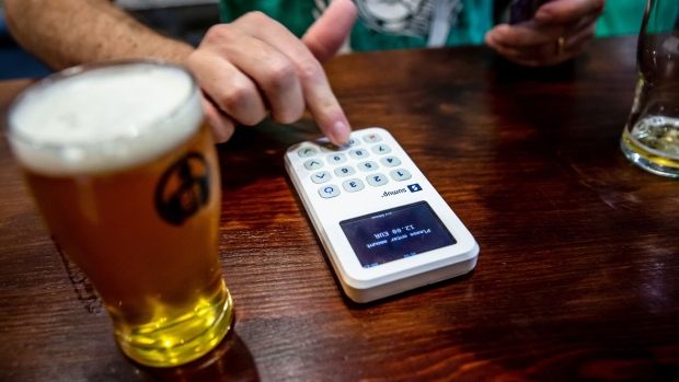 A bartender enters a transaction amount into a SumUp Payments Ltd. 3g card reader payment device at the Taproom Oitava Colina in the Marvila district of Lisbon, Portugal, on Friday, Sept. 13, 2019. Portugal is western Europe's most dynamic property market thanks to tax incentives for foreign buyers and a so-called golden visa program, which offers residence permits in return for a minimum 500,000-euro ($550,000) investment. Photographer: Angel Garcia/Bloomberg