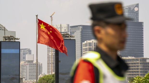 A Chinese flag in Pudong's Lujiazui Financial District in Shanghai, China, on Monday, Sept. 18, 2023. China's economy picked up steam in August as a summer travel boom and a heftier stimulus push boosted consumer spending and factory output, adding to nascent signs of stabilization. Photographer: Raul Ariano/Bloomberg