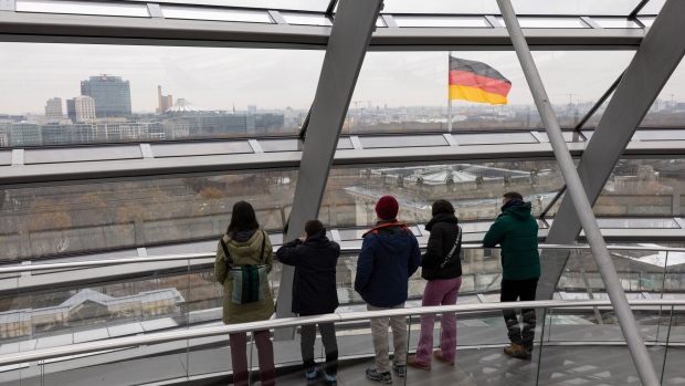 Tourists look out towards the city skyline from inside the glass dome of the Reichstag building in Berlin, Germany, on Friday, Dec. 8, 2023. Chancellor Olaf Scholz and top officials in his governing coalition will reconvene on Monday afternoon to try to seal an agreement on a revised 2024 budget, according to people familiar with the planning. Photographer: Andrey Rudakov/Bloomberg