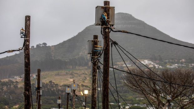 Electrical power lines above informal housing in the Imizamo Yethu township in the Hout Bay district of Cape Town, South Africa, on Thursday, Nov. 26, 2020. The decision to begin installing new steam generators at the Koeberg plant near Cape Town underscores state-owned Eskom's confidence that it will win approval to prolong production of low-emissions nuclear power into the middle of the century. Photographer: Dwayne Senior/Bloomberg