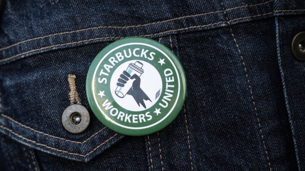 An organizer wears a Starbucks Workers United button outside a Starbucks coffee shop.