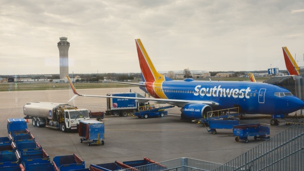 A Southwest Airlines aircraft at a gate at Austin–Bergstrom International Airport (AUS) in Austin, Texas, US, on Thursday, Feb. 16, 2023. Southwest Airlines Co.'s leaders will take a pay cut following the December breakdown that resulted in thousands of flight cancellations and more than $1 billion in added costs.