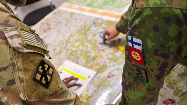 Representatives from the US Army, left, and the Finnish Army, right, inspect a map during a staged fight and evacuation of injured soldiers at a Combined Resolve multinational training exercise, with participating forces from the US, Finland and Romania, at the Hohenfels Training Area in Hohenfels, Germany, on Monday, Oct. 30, 2023. Combined Resolve is a multinational exercise conducted at the Joint Multinational Readiness Center, designed to test and certify brigade combat teams, as well as build interoperability with US allies and partners.