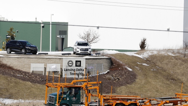 An empty car hauler passes the General Motors Co. Lansing Delta Township Assembly Plant in Lansing, Michigan, U.S., on Friday, Feb. 21, 2020. The plant started production in 2006 and employs over 2,500 Employees over two shifts.