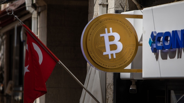 A Bitcoin logo sign by a Turkish national flag outside a cryptocurrency exchange kiosk in Istanbul, Turkey, on Tuesday, April 26, 2022. Both tech stocks and Bitcoin have notched big swings this year as the Federal Reserve becomes less accommodative as part of its fight to combat inflation. Photographer: Erhan Demirtas/Bloomberg