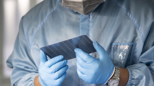 An employee inspects photovoltaic cells on the production line at the Longi Green Energy Technology Co. plant in Xi'an, Shaanxi Province, China, on Tuesday, July 21, 2020. Longi is the world's largest producer of solar wafers and the world's largest solar company by market value. Photographer: Qilai Shen/Bloomberg