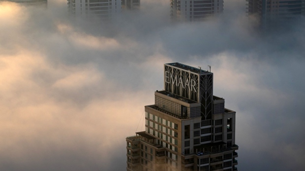 Morning fog shrouds Emaar signage atop a skyscraper in the Dubai Marina district. Photographer: Christopher Pike/Bloomberg