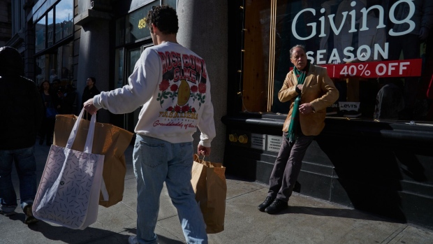 A shopper carries bags on Black Friday in the SoHo neighborhood of New York, US, on Friday, Nov. 24, 2023. An estimated 182 million people are planning to shop from Thanksgiving Day through Cyber Monday, the most since 2017, according to the National Retail Federation.