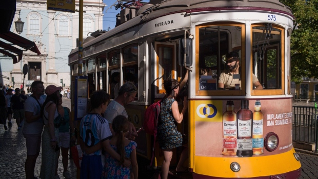 Tourists board a tram in the Baixa district of Lisbon. Photographer: Goncalo Fonseca/Bloomberg