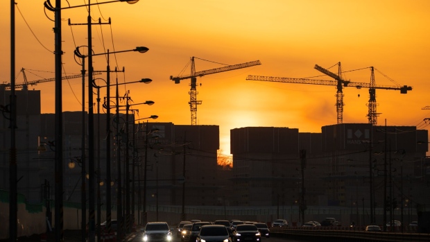 Vehicles drive along a highway as cranes stand silhouetted on a construction site at sunset in Incheon, South Korea, on Friday, Jan. 17, 2020. The South Korean government has launched a raft of property-related measures since taking office in 2017, with the latest in December dubbed “draconian” by CLSA. While the steps have yet to reel in all the pockets of price gains, some economists say they are contributing to a construction slump that was the main drag on economic growth in the third quarter. Photographer: SeongJoon Cho/Bloomberg