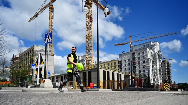 A construction worker crosses a road near cranes on residential apartment block building sites in the district of Hagastaden in Stockholm, Sweden, on Tuesday, June 1, 2021. The "red hot" housing market in Sweden is likely to slow down after the summer, according to the chief economist at the country's biggest bank, Svenska Handelsbanken AB. Photographer: Mikael Sjoberg/Bloomberg
