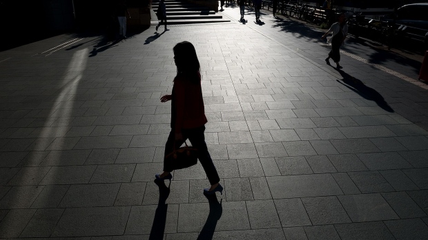 A woman walks near the Roppongi Hills complex in Tokyo. Photographer: Akio Kon/Bloomberg