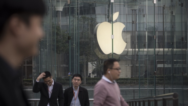 Pedestrians walk past an Apple Inc. store in Shanghai, China, on Tuesday, Nov. 27, 2018. Apple, which has lost a fifth of its value in a tech market rout since October, is poised for another setback after U.S. President Donald Trump suggested that 10 percent tariffs could be placed on mobile phones, like the iPhone, and laptops made in China. Photographer: Qilai Shen/Bloomberg