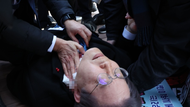BUSAN, SOUTH KOREA - JANUARY 02: (EDITORS NOTE: The identity of people in this image has been obscured at the request of the image source; image pixelated by source) In this handout image provided by The Busan Daily News, Lee Jae-myung, leader of the main opposition Democratic Party, lies down after he was attacked by an assailant of his neck during a visit to the construction site of an airport on January 02, 2024 in Busan, South Korea. Lee, leader of the opposition Democratic Party, was stabbed in the neck by an assailant while speaking to the media in the southern city of Busan. Lee survived and is in a stable condition at a local hospital. (Photo by The Busan Daily News via Getty Images) Photographer: Handout/Getty Images AsiaPac