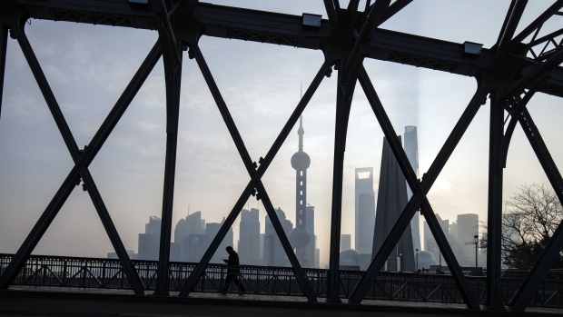 A pedestrian along a bridge passes buildings in Pudong's Lujiazui Financial District in Shanghai, China, on Tuesday, Jan. 9, 2024. Photographer: Qilai Shen/Bloomberg