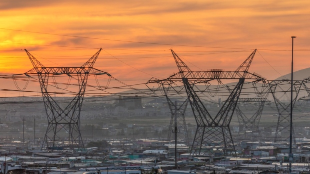 High-voltage electricity transmission towers above shacks in the Dunoon informal settlement area of Cape Town, South Africa, on Thursday, June 1, 2023. Cape Town, South Africa’s second-largest city, is in talks with Eskom Holdings SOC Ltd. to take over the supply of electricity in areas of the metro served by the state power utility.