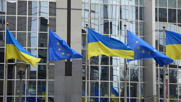 The flags of the European Union and Ukraine outside the EU Parliament building in Brussels, Belgium, on Friday, Feb. 24 2023. As Russia's invasion of Ukraine reaches the one-year mark, EU members failed to sign off on a new package of sanctions, with diplomats set to reconvene in an effort to get the measures over the line, according to people familiar with the matter. Photographer: Ksenia Kuleshova/Bloomberg