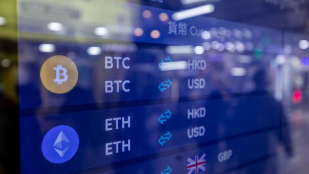 The Bitcoin, top, and Ethereum, bottom, logos on a screen at a cryptocurrency exchange in Hong Kong, China, on Tuesday, Dec. 5, 2023. Bitcoin shrugged off a dip in global stock markets to set another more than 19-month high, a sign of its decoupling from other assets.