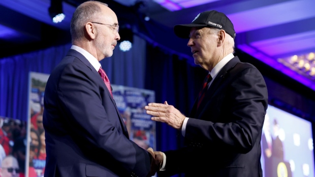 Shawn Fain shakes hands with Joe Biden at the United Auto Workers conference in Washington, DC on Jan. 24.