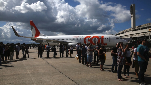 Attendees stand in line in front of a Boeing Co. aircraft operated by GOL Airlines SA during the International Brazil Air Show (IBAS) at Rio Galeao International Airport in Rio de Janeiro, Brazil, on Saturday, April 1, 2017. The event aims to bring together the aerospace supply chain, infrastructure, and commercial suppliers within the Brazilian aeronautics industry. Photographer: Dado Galdieri/Bloomberg