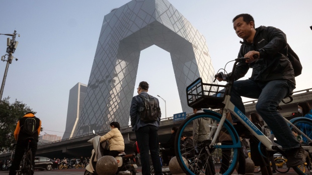 Morning commuters pass the CCTV tower in Beijing, China. Bloomberg