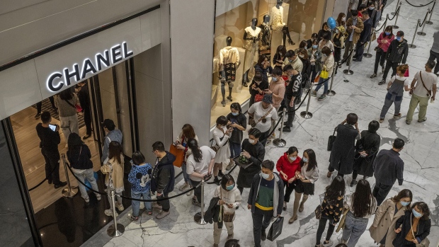 Shoppers wait in line outside a Chanel store at a mall in Beijing.