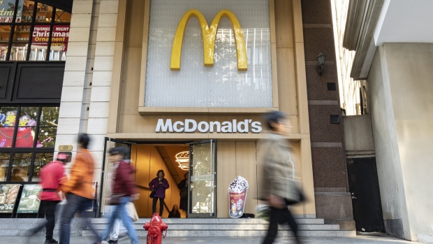 Pedestrians walk past a McDonald's Corp. restaurant in Shanghai, China, on Wednesday, Nov. 22, 2023. Carlyle Group Inc. agreed to sell its entire stake in McDonald's China operation to the hamburger chain operator for about $1.8 billion, reaping a 6.7 times return in one of the investment giant’s best exits from the Asian nation. Photographer: Qilai Shen/Bloomberg