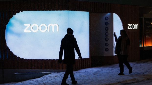 A pedestrian takes a picture of the Zoom Video Communications Inc. pavilion ahead of the World Economic Forum (WEF) in Davos, Switzerland, on Sunday, Jan. 15, 2023. The annual Davos gathering of political leaders, top executives and celebrities runs from January 16 to 20.