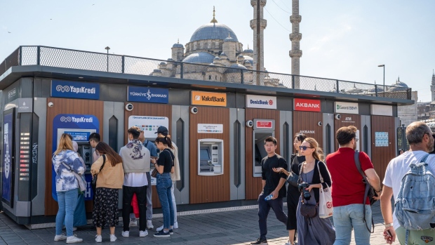 Customers use automatic teller machines (ATM) at a kiosk in the Beyazit district of Istanbul, Turkey, on Tuesday, Sept. 20, 2022. Key Turkish banks are buying back shares after stocks reversed an unprecedented rally last week, providing relief for brokerages hit by the rout.