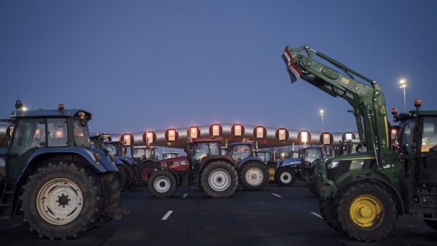 Farmers use their tractors to blockade toll road barriers outside Paris. Photographer: Cyril Marcilhacy/Bloomberg
