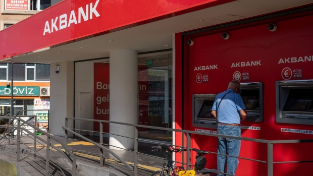 A customer uses an automatic teller machine (ATM) outside an Akbank TAS bank branch in the Kadikoy district of Istanbul, Turkey, on Thursday, Sept. 29, 2022. Akbank is offering lenders improved returns on its upcoming October dual-currency loan, making it the most expensive loan ever for the Turkish lender, after global borrowing costs rose and major rating firms cut the sovereign’s credit grade.