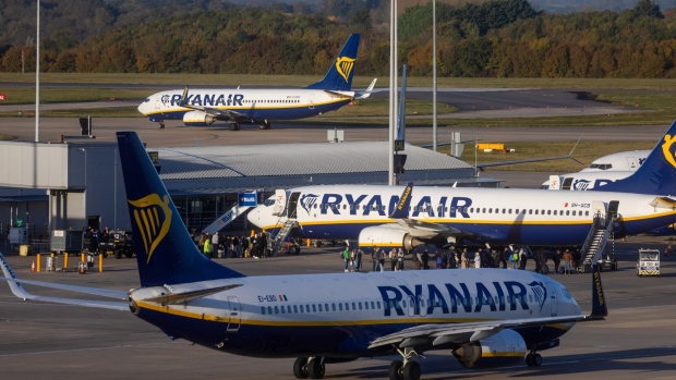 Passengers board an aircraft, operated by Ryanair Holdings Plc, on the tarmac at London Stansted Airport, operated by Manchester Airport Plc, in Stansted, UK, on Monday, Nov. 6, 2023. Ryanair will pay out a dividend of €400 million ($430 million) and plans to hand over about a quarter of annual profit to shareholders as Europe's biggest discount airline benefits from growing traffic.