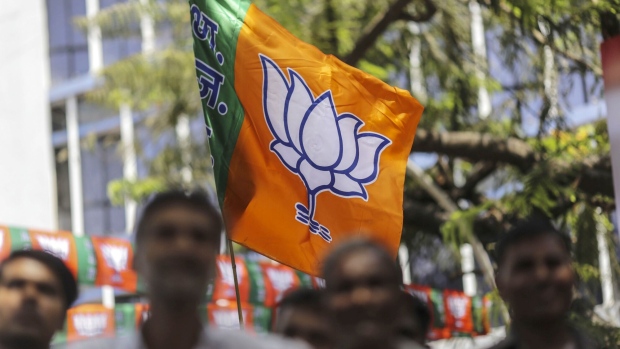Supporters wave a Bhartiya Janata Party (BJP) outside the party's state office in Mumbai, India, on Thursday, May 23, 2019. Indian Prime Minister Narendra Modi is set to win a majority on his own in India’s general election, with his Bharatiya Janata Party surging to a commanding lead in early vote counting. Photographer: Dhiraj Singh/Bloomberg