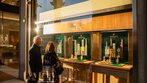 Shoppers look in the window at a Rolex SA luxury watch store near Piazza Duomo in Milan, Italy, on Wednesday Nov. 15, 2023. A possible downgrade of Italy to junk this week would be hugely symbolic, potentially consequential — and very controversial.