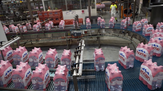 Bottles of Evian water move along the production line at the new Evian mineral water bottling plant, owned by Danone SA, near Evian, France, on Tuesday, Sept. 12, 2017. Evian aims to become the first major spring water brand to go carbon neutral amid criticism that packaging water from the French Alps and transporting it around the world in plastic bottles causes unnecessary environmental damage. Photographer: Stefan Wermuth/Bloomberg