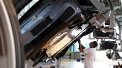 A worker secures a battery pack fitted to the undercarriage of a Volkswagen AG (VW) ID.3 electric automobile in an assembly line cradle at the automaker's factory in Dresden, Germany, on Tuesday, June 8, 2021. Photographer: Liesa Johannssen-Koppitz/Bloomberg