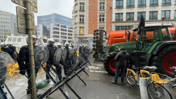 Riot police man a blockade as they face farmers.