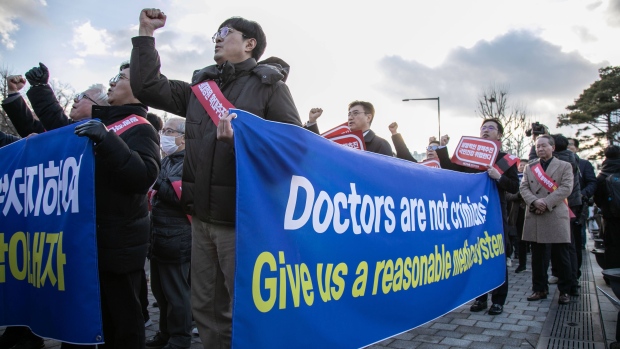 Demonstrators march during a protest in Seoul on Feb. 25. Photographer: Jean Chung/Bloomberg