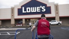 A worker moves empty carts outside a Lowe's store in Albany, New York. Photographer: Angus Mordant/Bloomberg